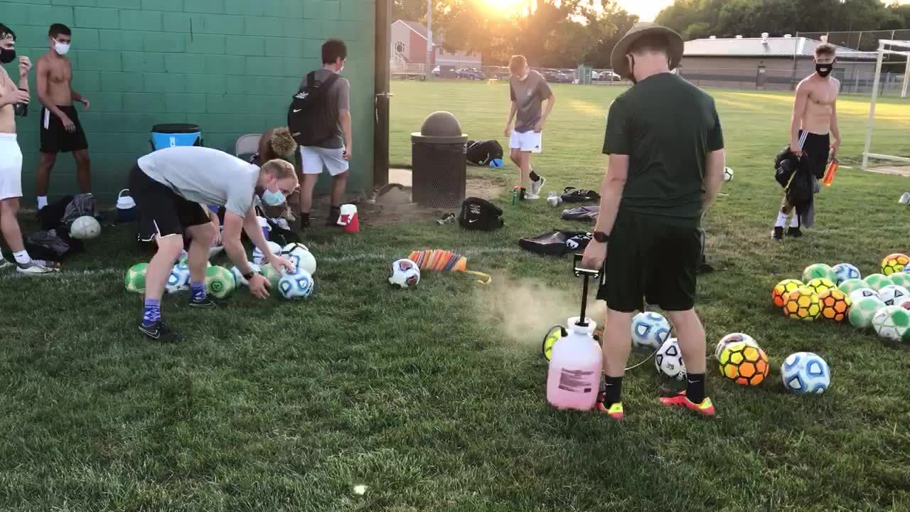 Northridge boys soccer coaches sanitize the soccer balls after practice